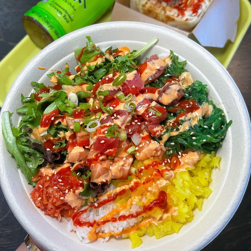 A colorful BOPJO Korean-Mexican Grill poke bowl with tuna, salmon, seaweed, and kimchi.
