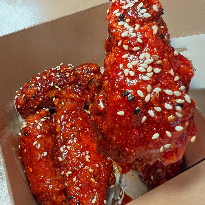 BOPJO Korean-Mexican Grill's spicy Korean fried chicken wings, coated in red sauce and sesame seeds.
